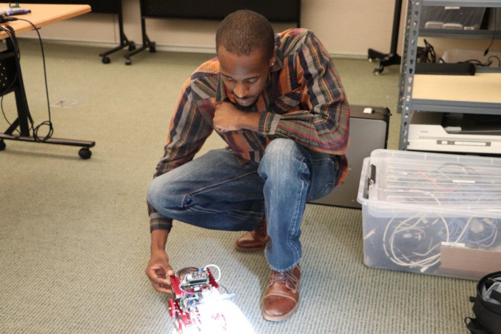 McIntosh checks out a robot his teacher, Stephen Wanser, built for the class.