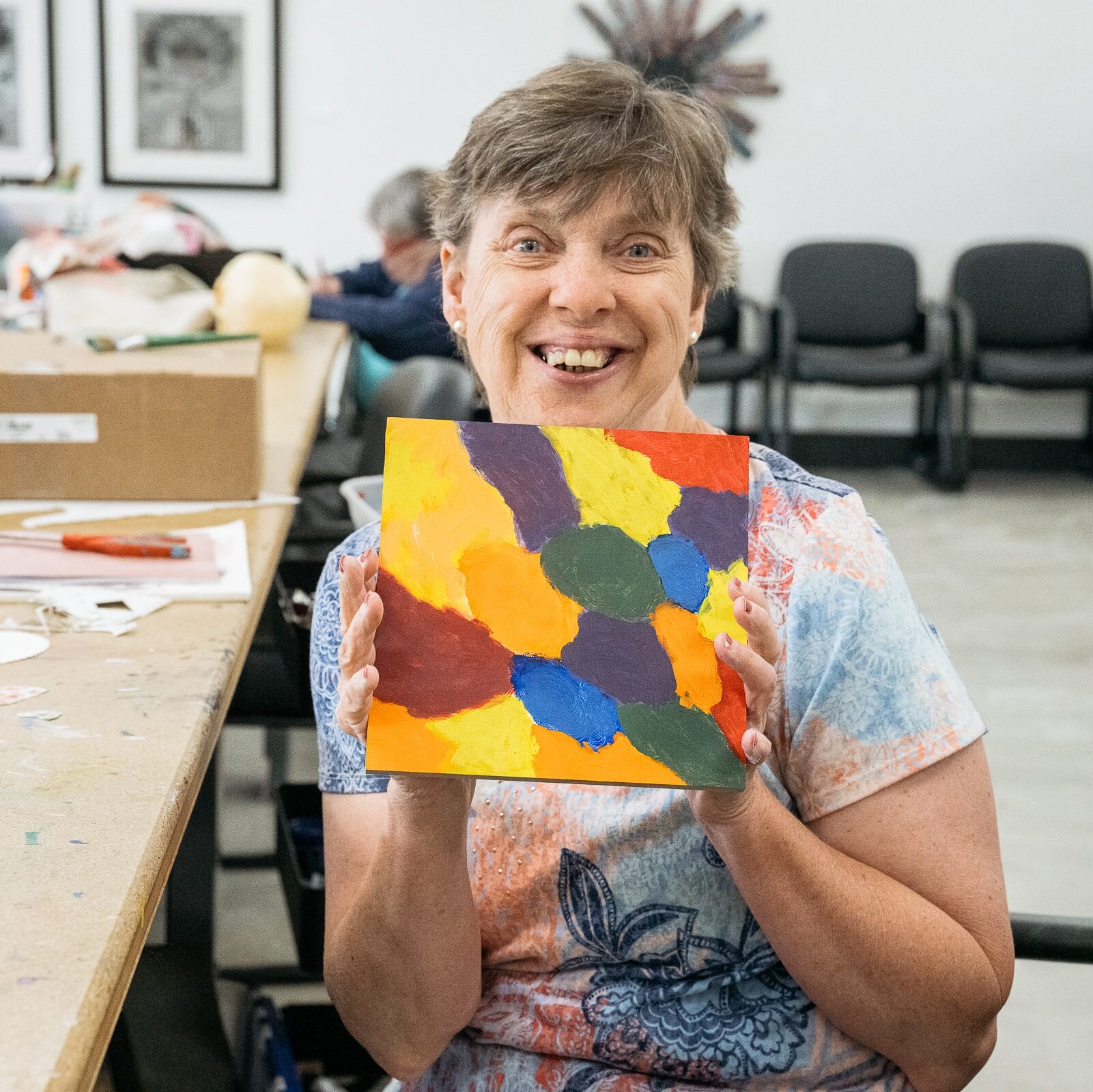 An artist holding a painting